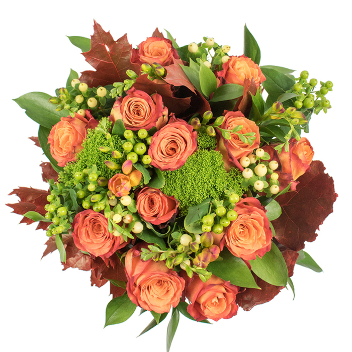 Captured in a top-down view, this richly textured bouquet feels like a small, cultivated wood of flowers. The composition is dense and circular, anchored by many open-faced roses whose petals blend soft peach, coral-orange and deeper russet-each bloom showing a delicate gradient from warm core to reddish-brown edges. Interwoven among these are clusters of Hypericum berries that alternate between a vibrant lime and a creamy pale yellow, adding small, glossy points of contrast that break the mass of petals with cheerful punctuation. Textural contrast comes from the green-limited Green Trick dianthus - tufted, velvety forms that read as living moss - and from prominent, lobed leaves in dark burgundy and burnt orange that resemble autumnal oak or maple. The remaining fresh foliage, varied in shape and sheen, fills the negative space and lends the arrangement a lush, layered depth. Light lies softly across the bouquet, revealing the rose velour and bouncing on the berries' surfaces, while mild shadows emphasize the density of the grouping; the overall scent suggests a union of rose sweetness with an underlying earthy, mossy note. This arrangement suits autumnal gatherings and Thanksgiving tables, and would sit beautifully in a cosy Spitalfields flat after a stroll through Liverpool Street or a morning at the market. Crafted with attention to seasonal colour and texture, it reads as both an elegant table centrepiece and a heartfelt, tactile gift that celebrates harvest and home.